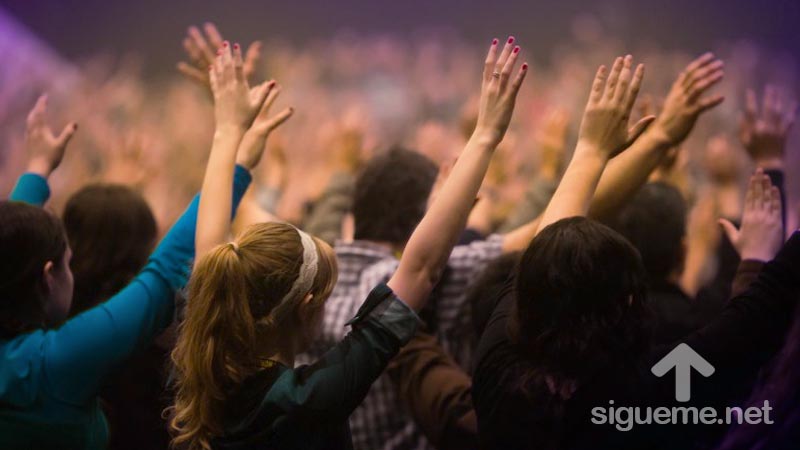 Creyentes cristianos levantan sus manos a Dios en oración