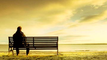 Hombre solo, sentado mirando hacia el horizonte