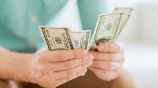 Hombre con billetes dolares en sus manos