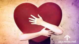 Joven abrazando un corazón simbolizando el amor