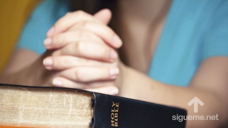 Mujer en oracion a Dios sobre su Biblia, la Palabra de Dios