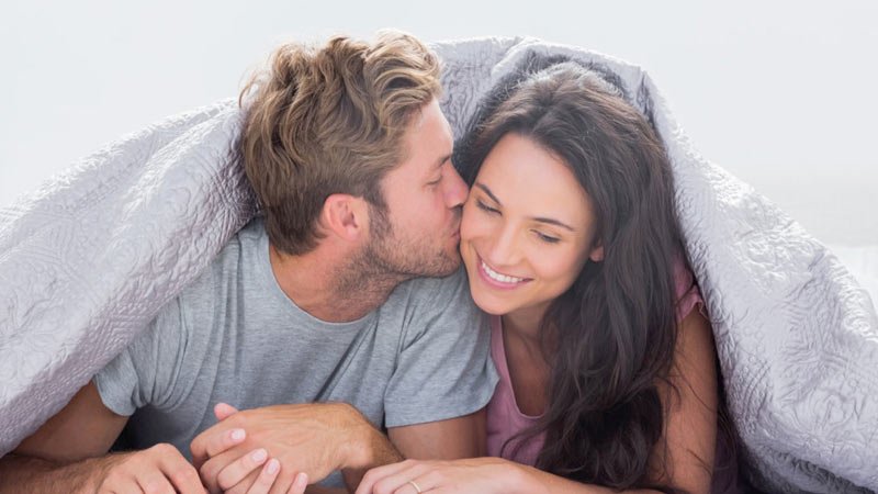 Pareja de jovenes novios cristianos en la cama