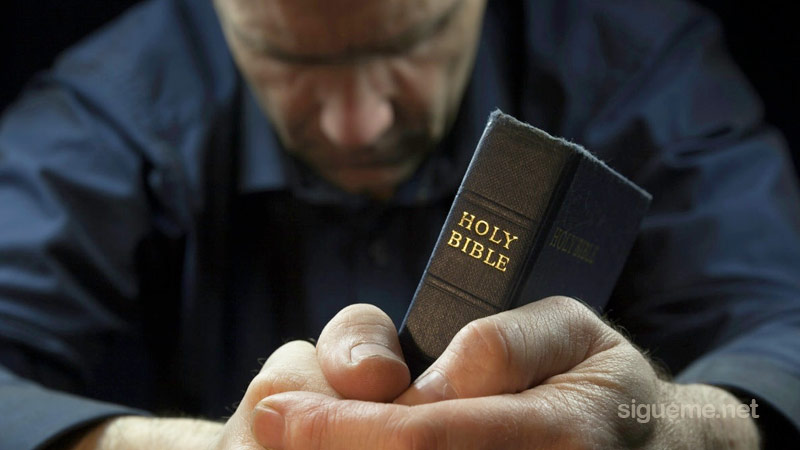Ministro cristiano orando a Dios y leyendo la Biblia en su devocional