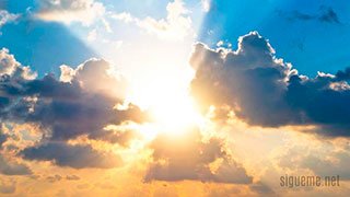 cielo azul con nubes y rayos de sol
