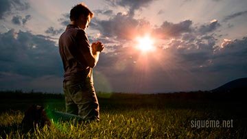 Joven de rodillas orando ante Dios