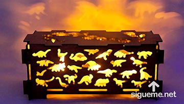 Una caja con iluminacion interna con figuras de dinosaurios